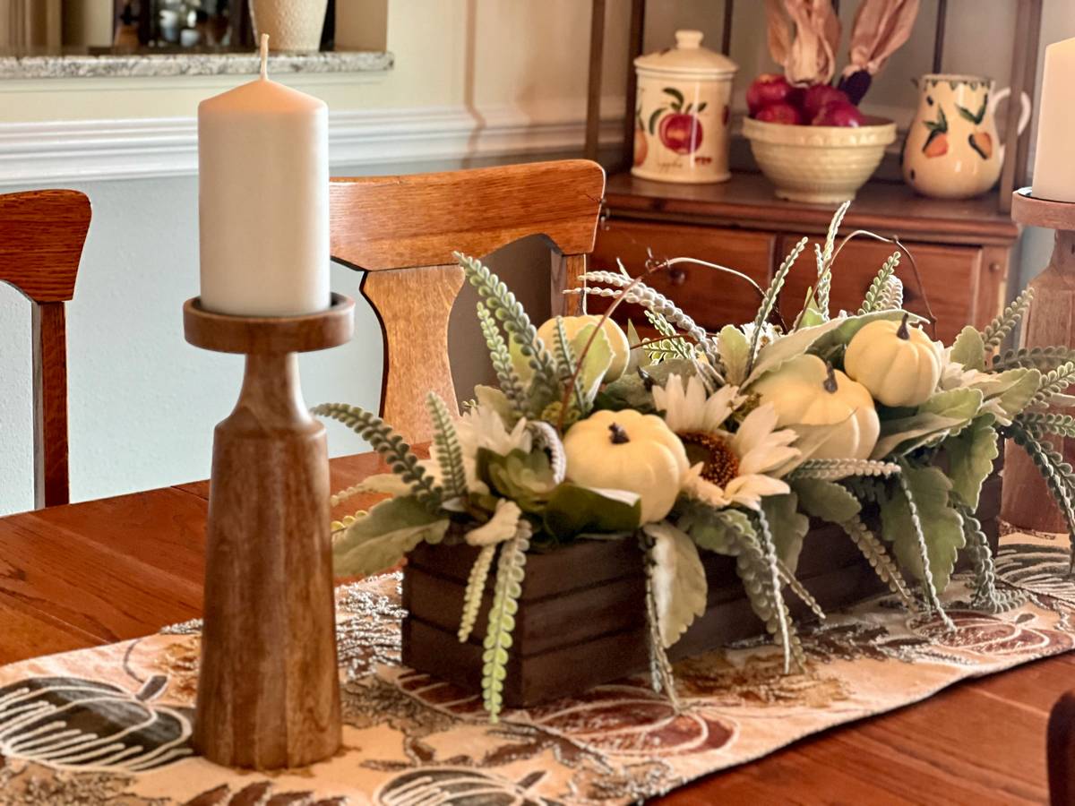 A cozy, clutter-free dining nook with handmade paper leaves, neutral linen napkins, and a low-profile ceramic centerpiece — all labeled 'at home thanksgiving decorations'