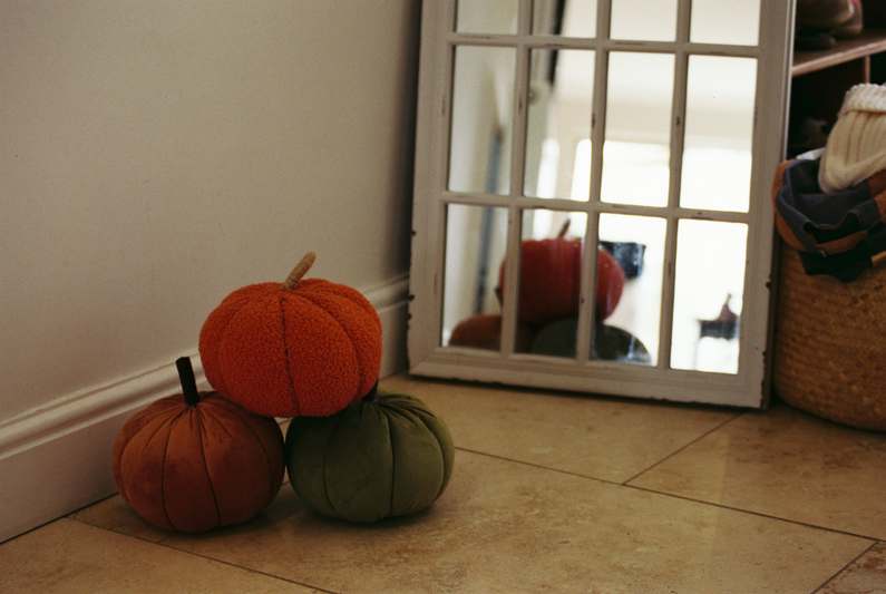 Rustic Thanksgiving table setting with pumpkins, candles, fall foliage, and linen napkins